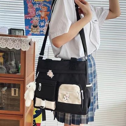 A cute crossbody bag perfect for young girls, featuring two badges and a bear charm.